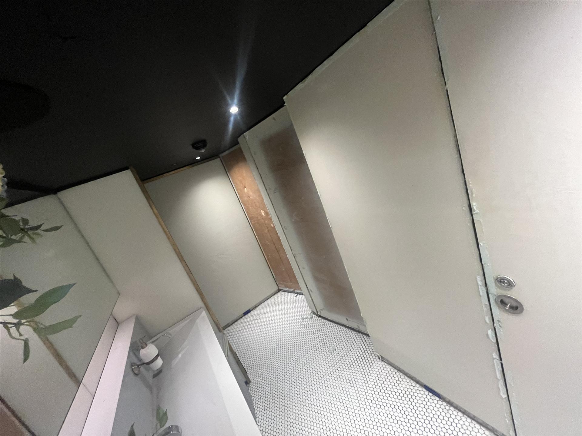 Before, restaurant toilet cubicles awaiting wallpaper installation, London